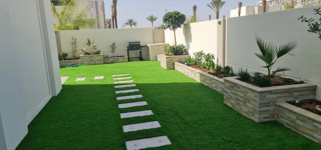 Turf courtyard with stepping stones and stone planters
