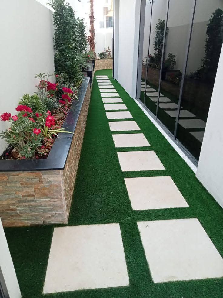 Large pavers and turf beside a stone-clad planter