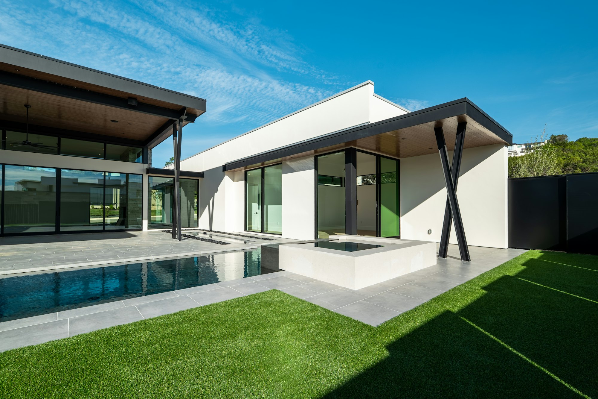Modern Dubai villa with a pool, green lawn and covered terrace