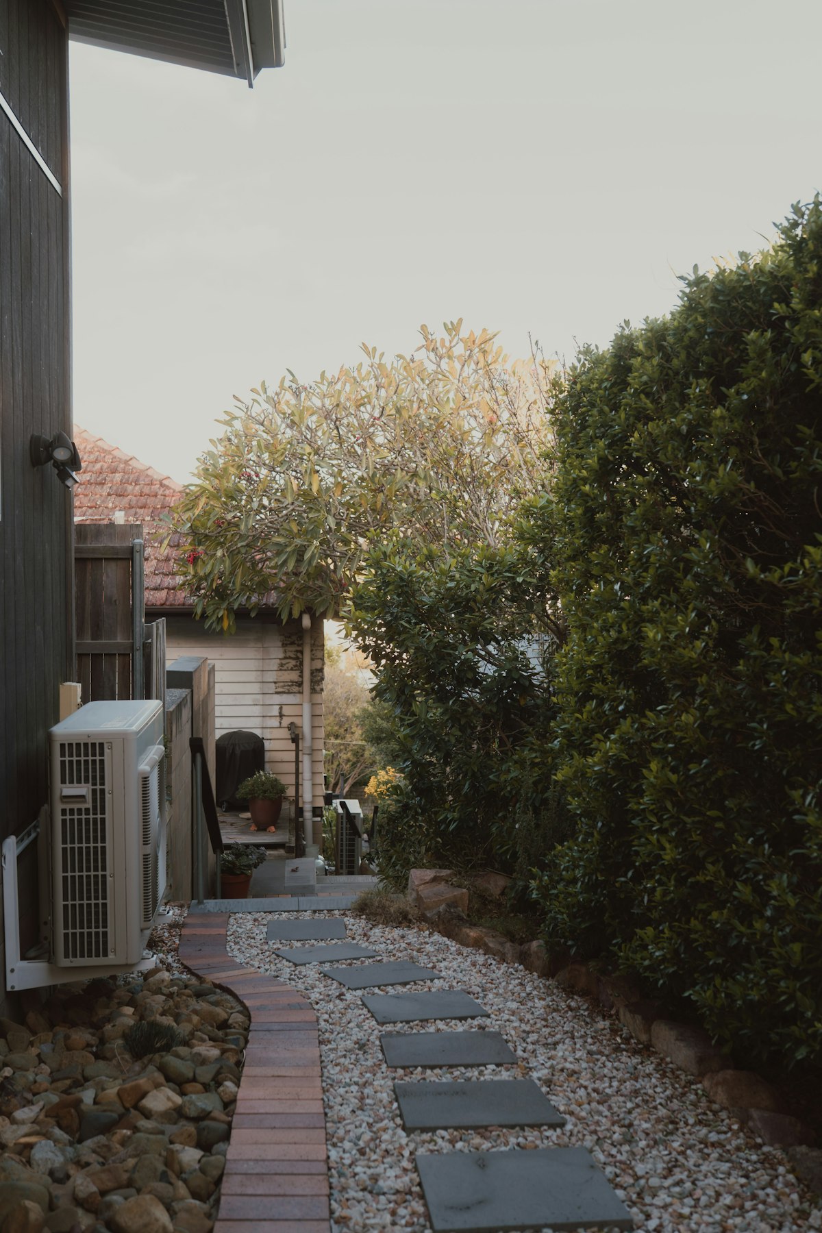 Narrow side path with stepping stones and greenery